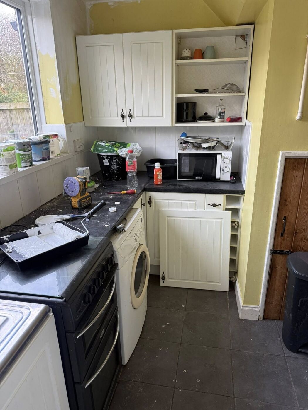 Tired kitchen before refurbishment, with cream units